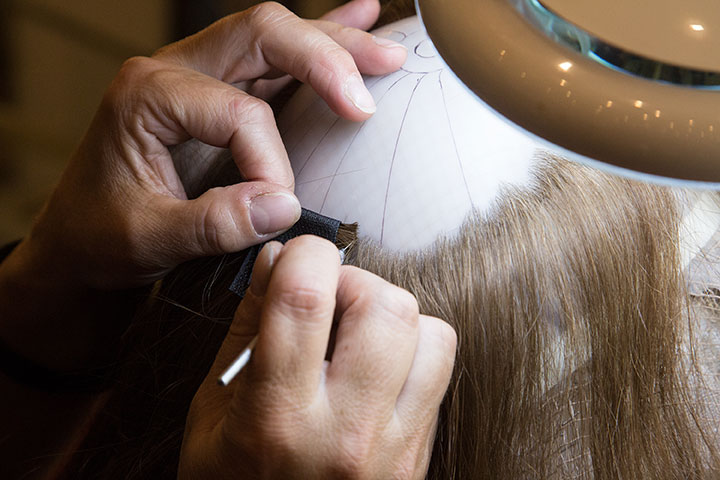 Hands individually finishing the hair of a CNC® cranial prosthesis