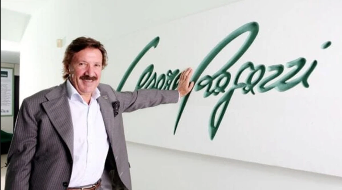 Cesare Ragazzi standing beside the Cesare Ragazzi signature logo on a wall